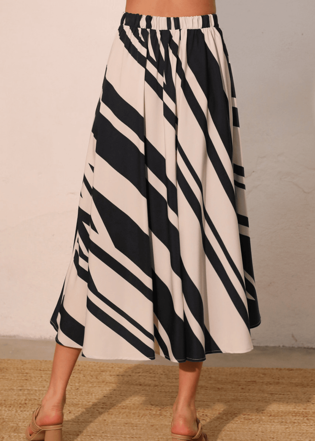 Effortlessly versatile, the Sienna Stripe Midi Swing Skirt delivers timeless appeal with its classic black and ivory vertical stripes. The flowing midi silhouette flatters all body types while the lightweight fabric and elastic waistband ensure comfort from morning through evening. 