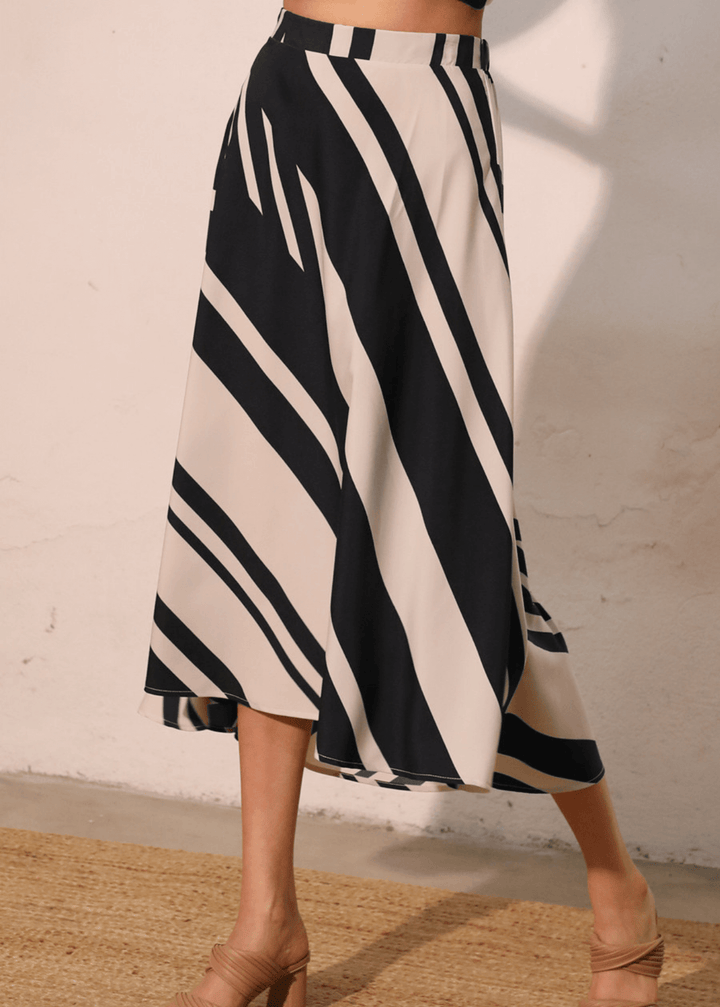 Effortlessly versatile, the Sienna Stripe Midi Swing Skirt delivers timeless appeal with its classic black and ivory vertical stripes. The flowing midi silhouette flatters all body types while the lightweight fabric and elastic waistband ensure comfort from morning through evening. 