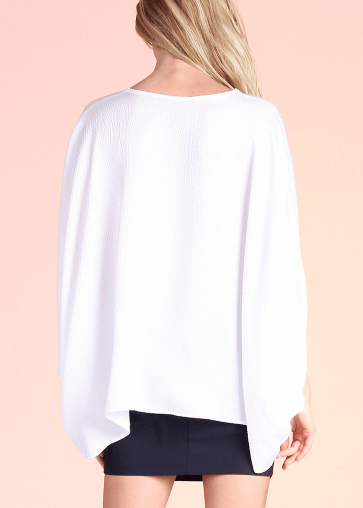 Elevate your wardrobe with this versatile caftan top, crafted from luxurious hammered satin in crisp bright white. The structured V-neckline and gracefully billowing short sleeves create a refined silhouette that transitions effortlessly from casual to polished. Layer it over fitted bottoms for understated elegance, or wear it loose with denim for relaxed sophistication. Made in the USA with attention to quality construction, this piece adapts to your personal style and occasion.