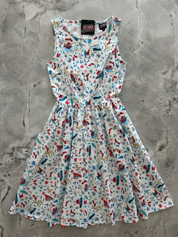 Introducing our Winter Cheer Vintage Dress. This dress boasts a fun and playful print featuring gnomes, sleds, ice skates, mittens, and reindeer. It&