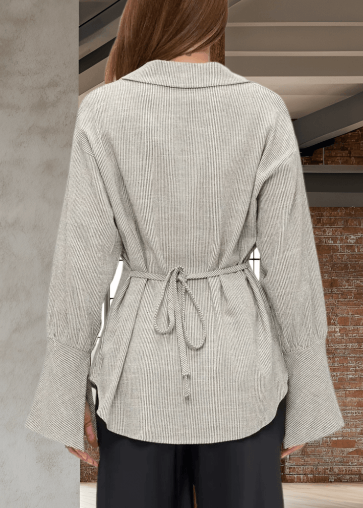 Elevate your wardrobe with the Made in USA Gabriella Cuff Detail Striped Top, featuring a classic collared design and long sleeves with stylish split bell cuffs. The tie-back detail adds a modern twist, while the subtle charcoal pinstripes on ivory make for a versatile, sophisticated look. Crafted from a breathable blend of cotton, rayon, and linen, this top offers all-day comfort and easy care with machine washable fabric. 