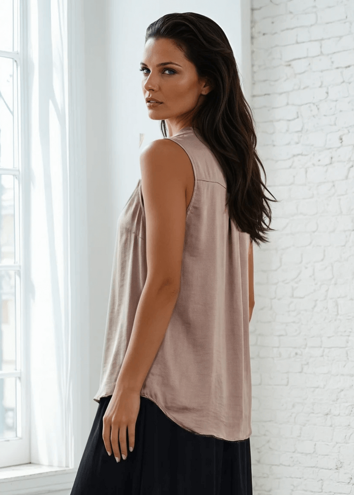 Elevate your wardrobe with this sophisticated taupe poly silk top, designed for effortless elegance. The sleeveless silhouette and flattering V-neckline create a refined look, while strategic pleating at the front and back adds subtle dimension and movement. 