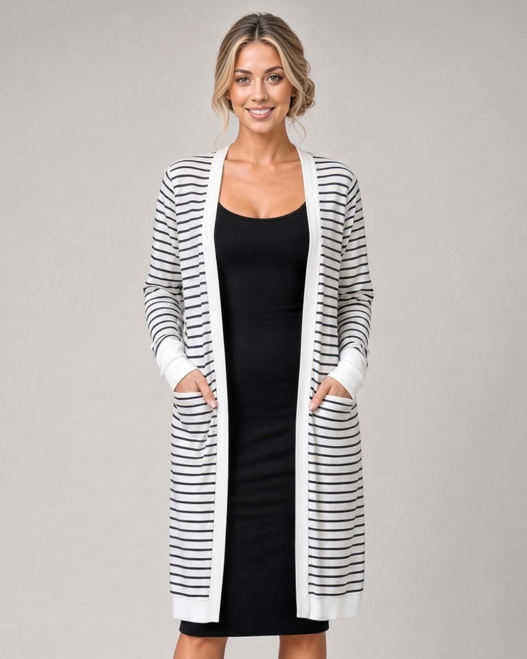 Made in USA women's white long sleeve open-front midi cardigan with thin black horizontal stripes and front patch pockets, styled over a black dress
