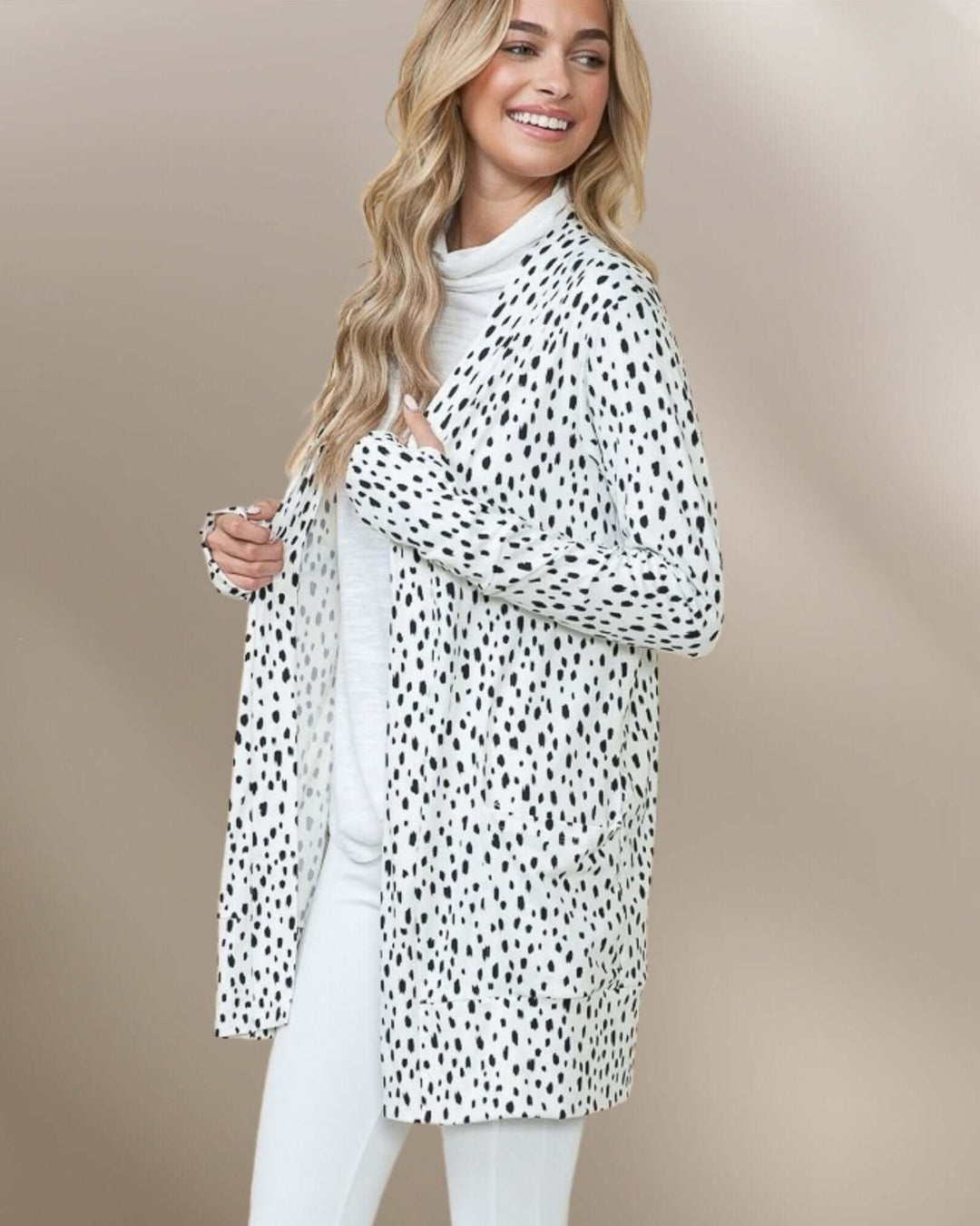 Made in USA Dolly Dot Print Cardigan: front view of model holding cardigan open over white outfit