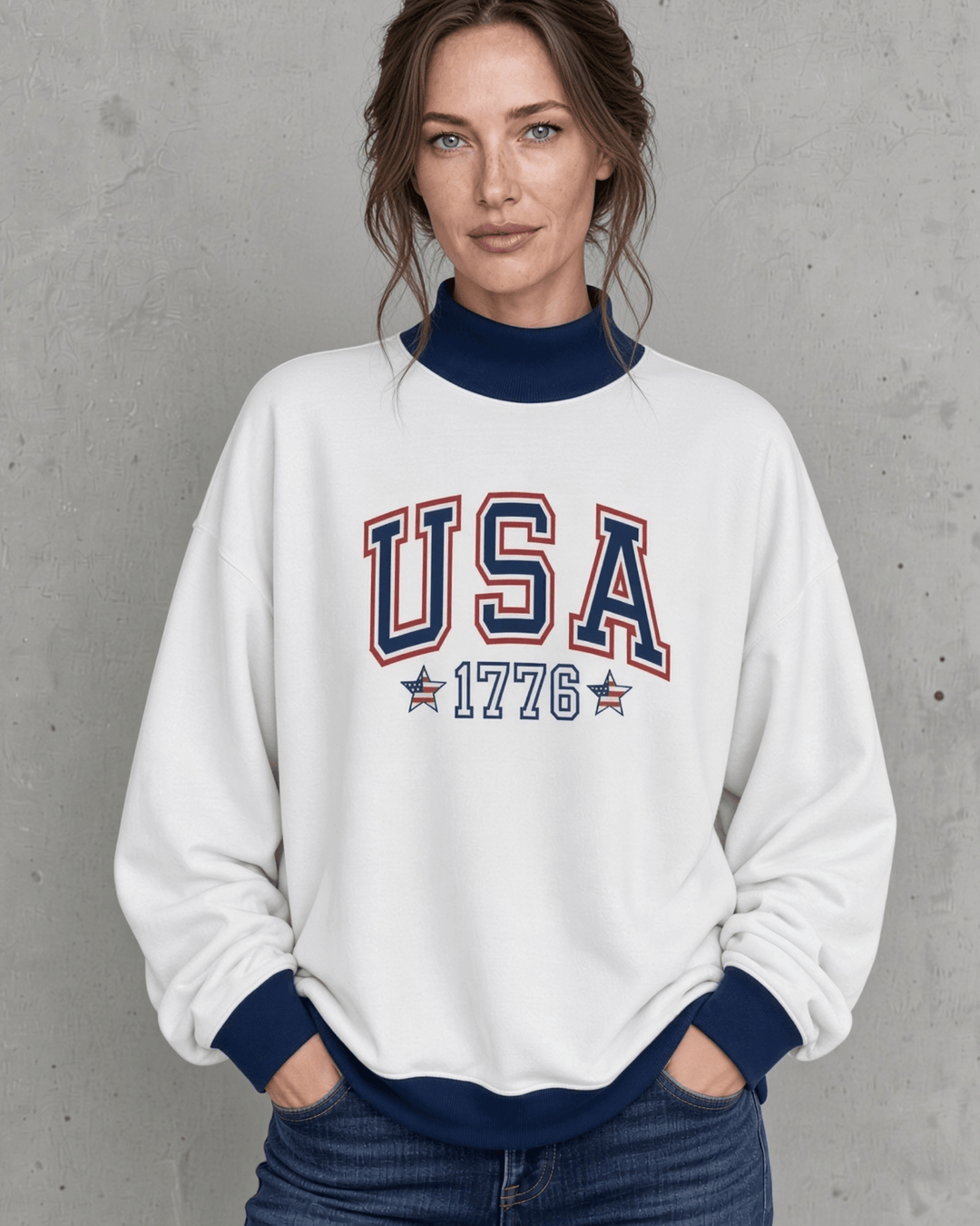 Made in USA. Layer up for fall in a women's white oversized French terry sweatshirt with navy trim and a red, white and blue USA 1776 graphic. Be Patriotic Year Round.