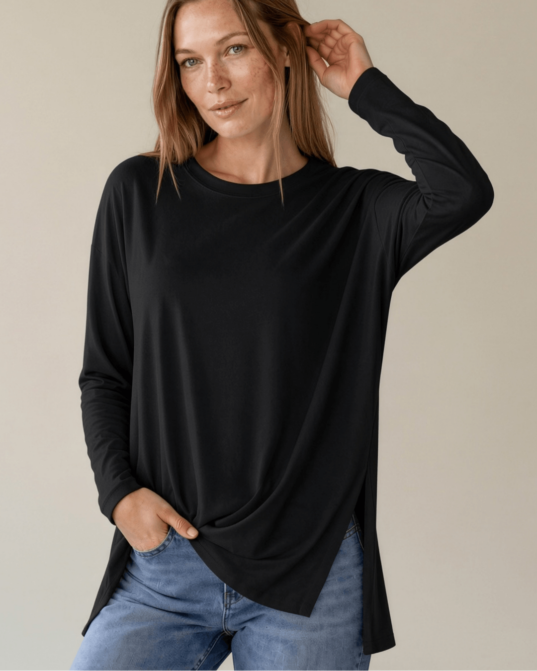Made in USA. Women's black long sleeve cotton top with a crew neck, relaxed fit and side slits. Soft 95% cotton with stretch for easy everyday layering.