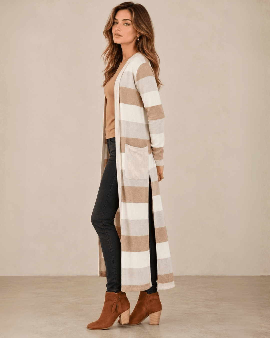 Woman wearing Made in USA the Lilian taupe striped longline cardigan with an open front, long sleeves, patch pockets and side slits for easy everyday layering.