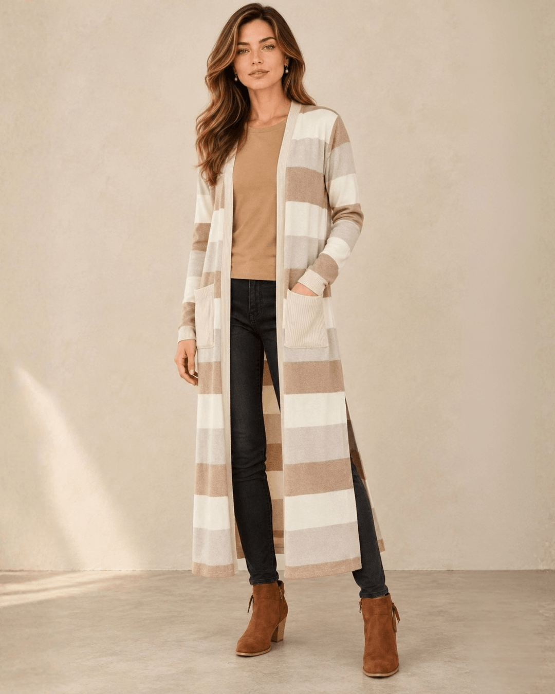 Woman wearing Made in USA the Lilian taupe striped longline cardigan with an open front, long sleeves, patch pockets and side slits for easy everyday layering.