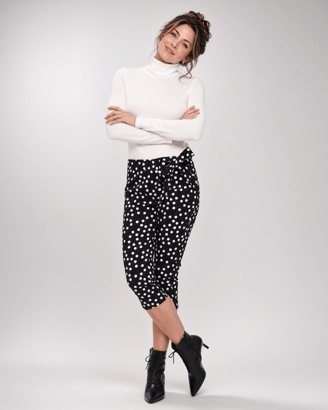 Made in USA. Polly black and white polka dot capri pants feature cotton-rich stretch, a bow waist tie and side-slit hems. A playful statement pair! Style 5460PT by Renee C