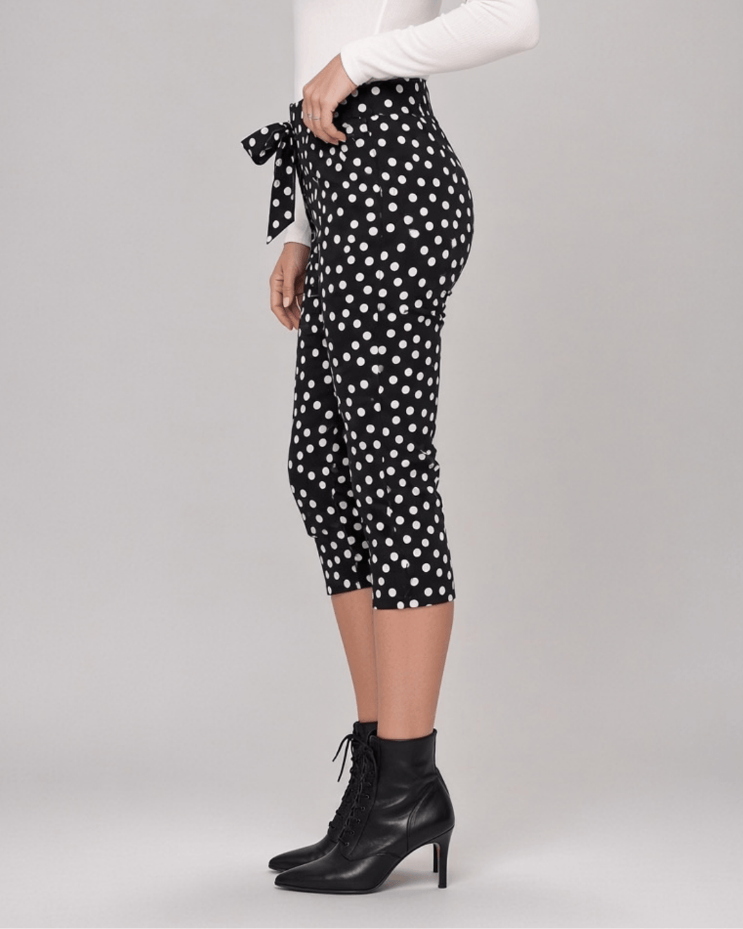 Made in USA. Polly black and white polka dot capri pants feature cotton-rich stretch, a bow waist tie and side-slit hems. A playful statement pair! Style 5460PT by Renee C