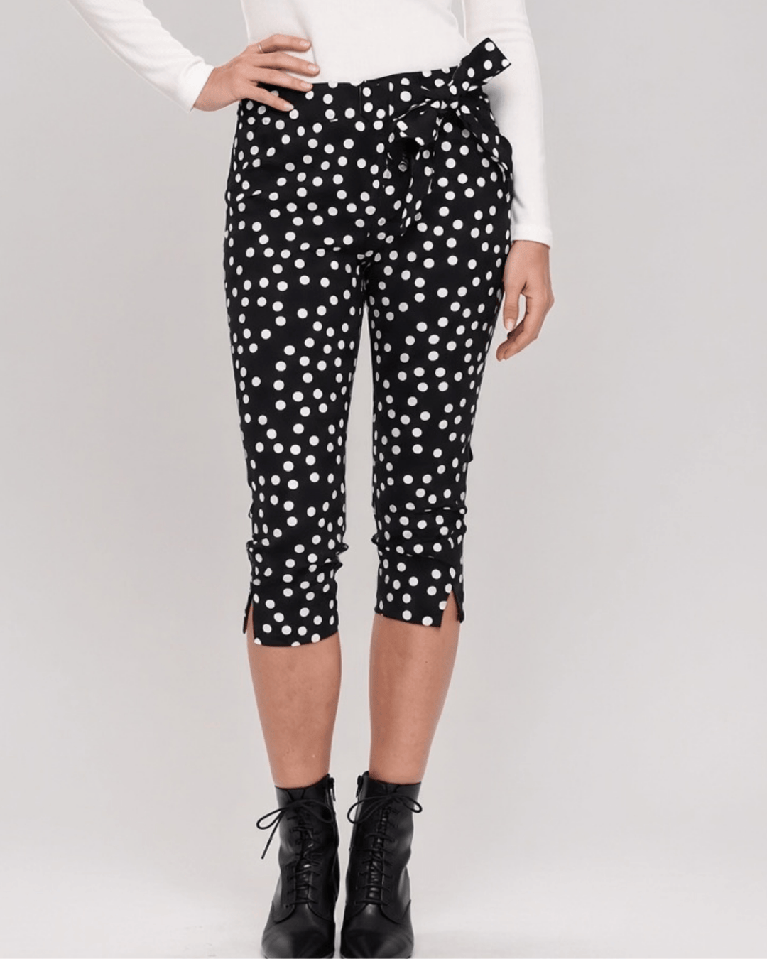 Made in USA. Polly black and white polka dot capri pants feature cotton-rich stretch, a bow waist tie and side-slit hems. A playful statement pair! Style 5460PT by Renee C