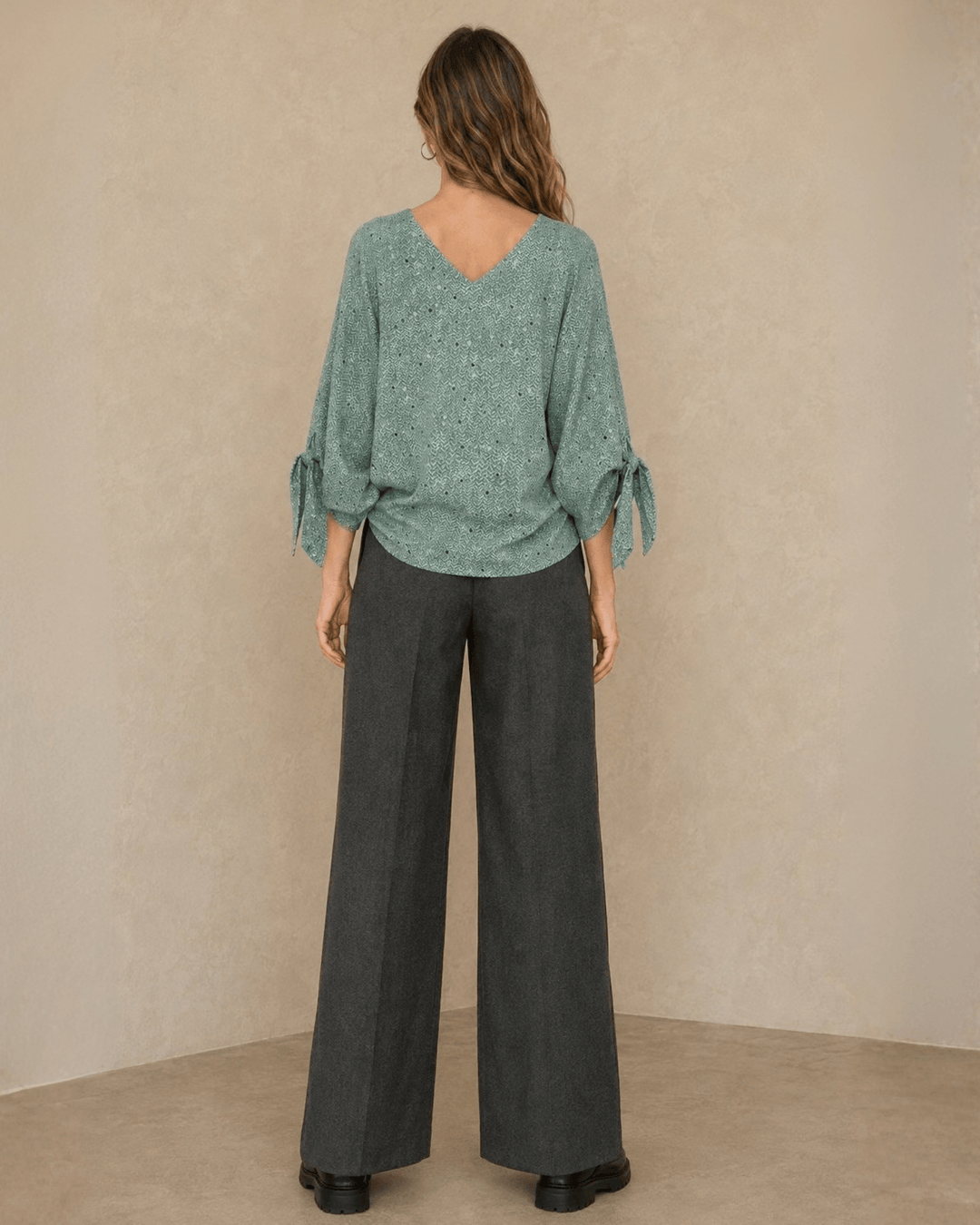 Made in USA. Green confetti dot chevron blouse with a V-neck, dolman sleeves and adjustable cuff ties. Lightweight woven fabric with a loose, flowing fit.