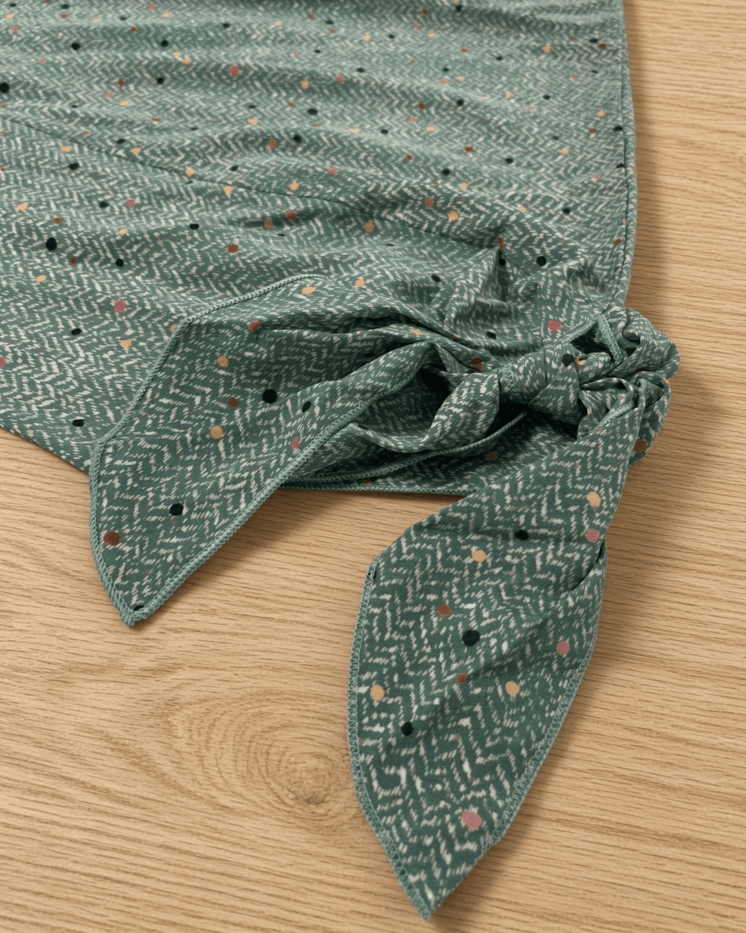 Made in USA. Green confetti dot chevron blouse with a V-neck, dolman sleeves and adjustable cuff ties. Lightweight woven fabric with a loose, flowing fit.