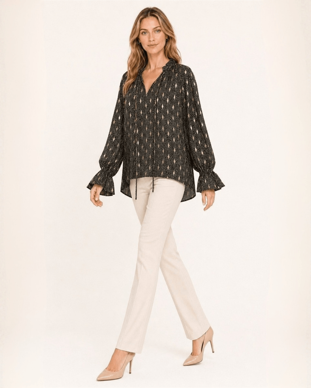 Made in USA Radiant Ruffle Neck Foil Print Blouse - Black: full-length walking view with cream pants and heels