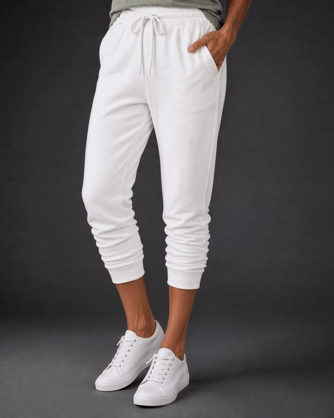 Made in USA, these white cropped joggers blend 62% cotton and 38% polyester, with a relaxed fit, pockets, and cuffed hems. Sizes S–L.