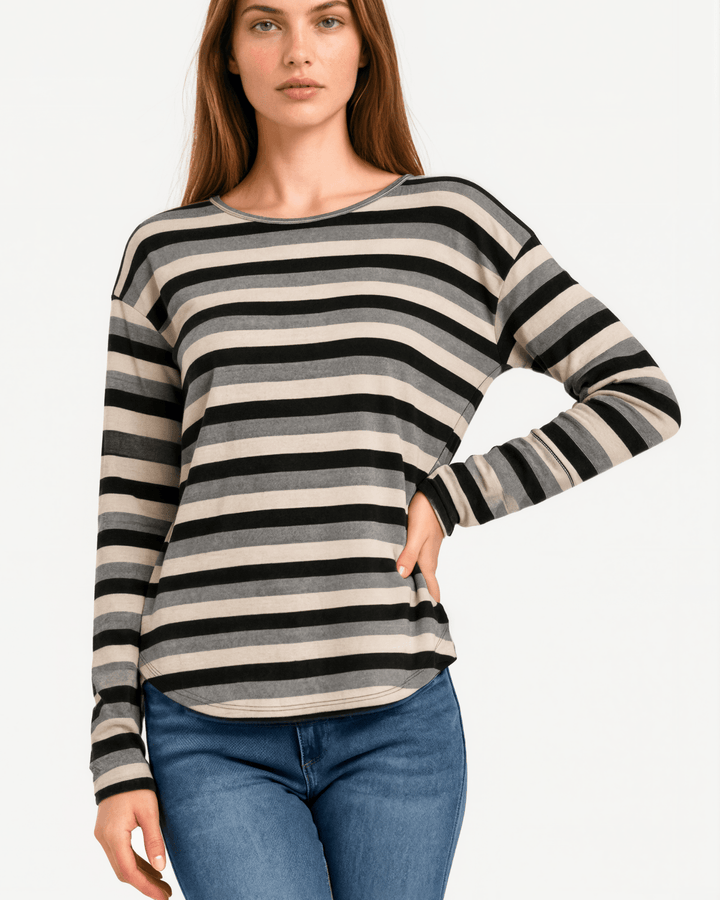 Made in USA Stella women’s grey, black, and cream striped long sleeve top with a round neckline, dropped shoulders, relaxed oversized fit, and rounded hem.