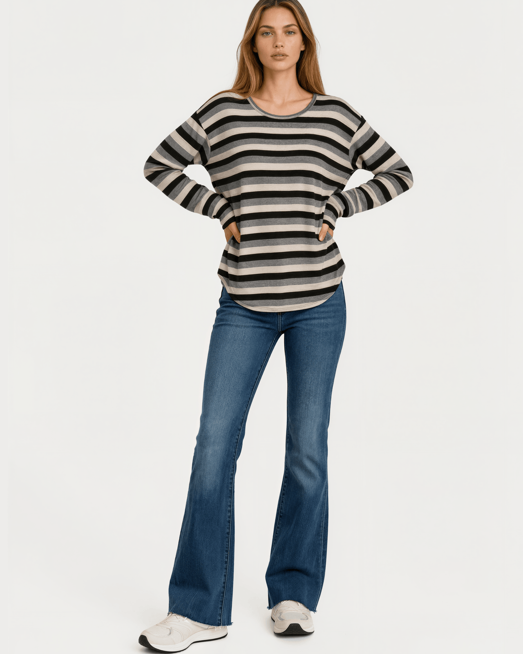 Made in USA Stella women’s grey, black, and cream striped long sleeve top with a round neckline, dropped shoulders, relaxed oversized fit, and rounded hem.