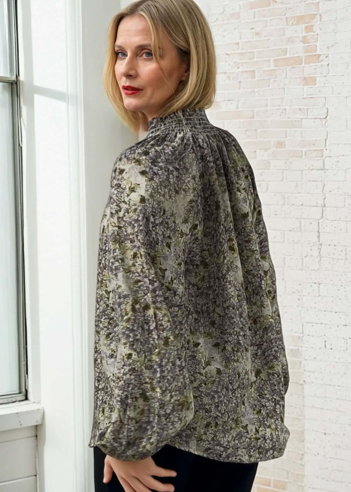 The USA made Ava Mock Stand Collar Blouse features a delicate smocked high collar with a split neckline, adding subtle sophistication to your wardrobe. Designed with long puff sleeves and elasticized cuffs, it offers both comfort and refined style