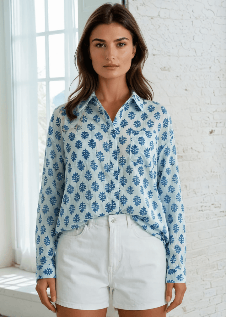 Effortless elegance meets everyday comfort in this Made in USA vintage-washed cotton-voile button-down. Hand-block inspired indigo florals dance across a serene sky-blue canvas, creating a timeless aesthetic that transitions seamlessly from casual to polished. The lightweight, breathable 100% cotton construction keeps you cool and comfortable.