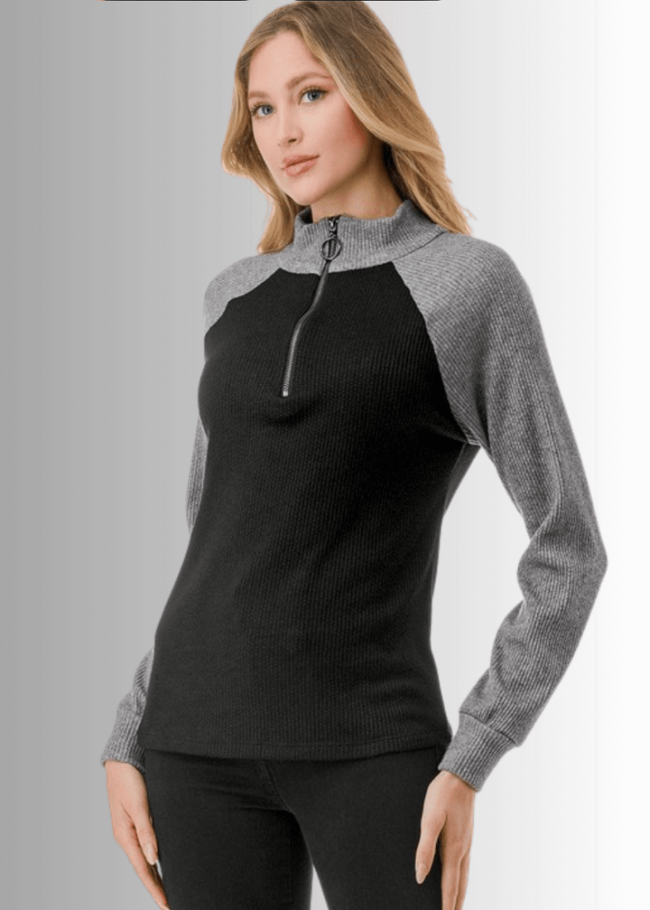 This Paige Color Block Zip Detail Top offers a sleek, semi-fitted silhouette crafted from medium-weight fabric, perfect for layering or standalone wear. Featuring a stylish quarter zip front and a modern black and gray color block design, it combines comfort with contemporary appeal. Made in the USA