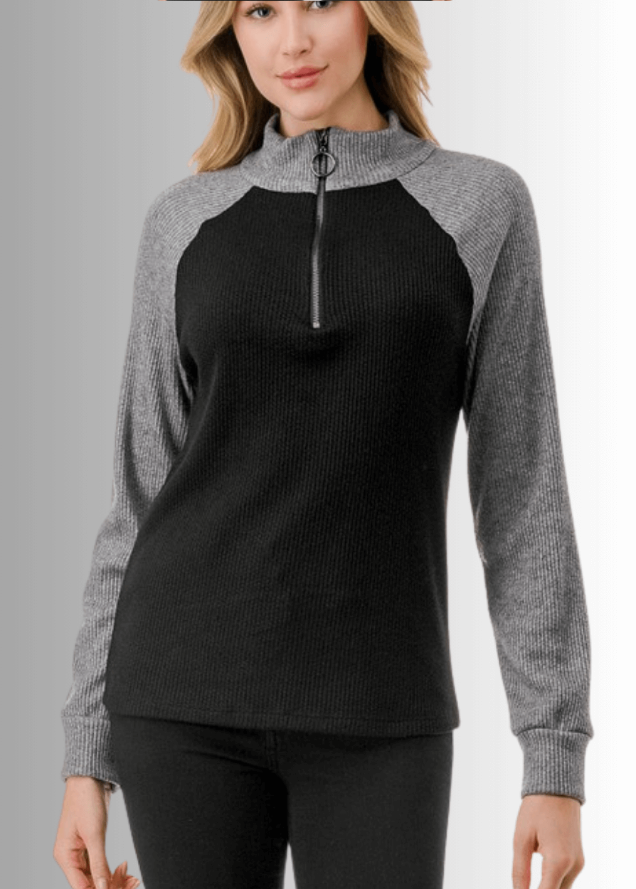 This Paige Color Block Zip Detail Top offers a sleek, semi-fitted silhouette crafted from medium-weight fabric, perfect for layering or standalone wear. Featuring a stylish quarter zip front and a modern black and gray color block design, it combines comfort with contemporary appeal. Made in the USA