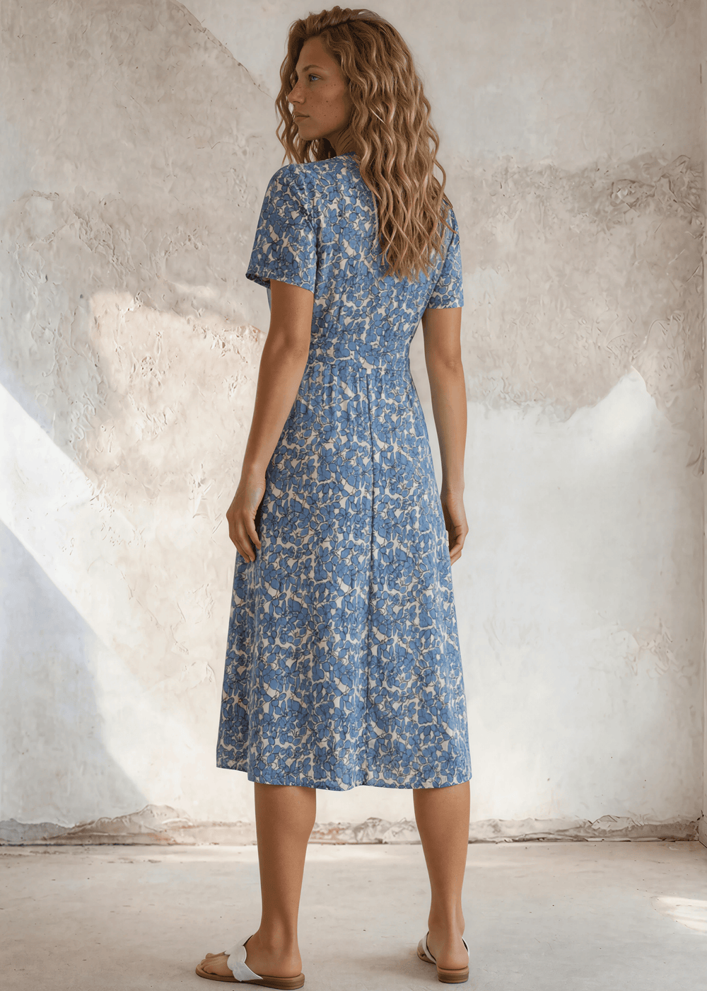 USA-made women's flutter sleeve faux-wrap midi dress in a blue floral print. Smocked waist, flared skirt, sizes XS–L