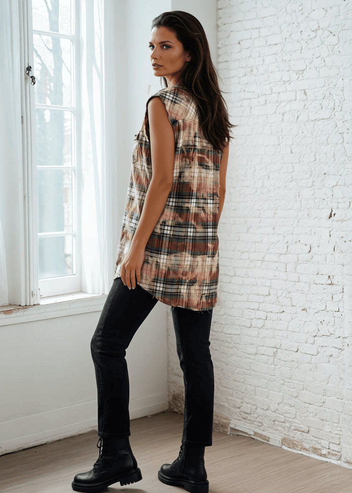 Meet The Sedona Sunset Sleeveless Plaid Flannel Tunic - a sleeveless, boho-chic essential designed for effortless layering and laid-back luxury. Crafted in Los Angeles from ultra-soft, vintage-washed plaid, this one-of-a-kind piece features hand-bleached details, raw frayed edges, and classic chest pockets for a relaxed yet elevated vibe. Its tunic length makes it versatile enough to wear open over denim shorts or buttoned up as a dress.