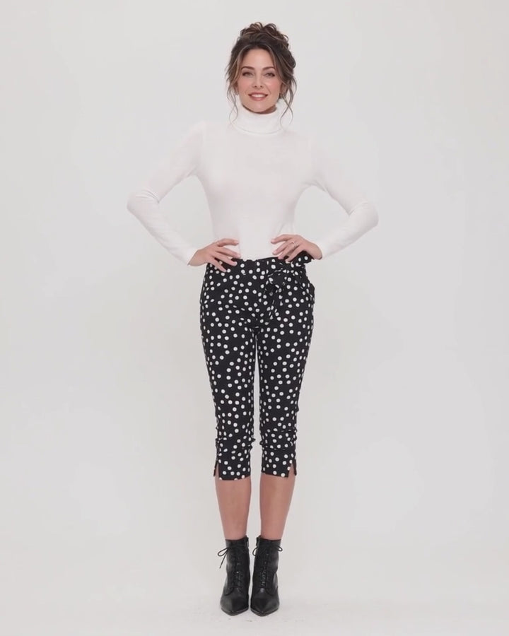 Made in USA. Polly black and white polka dot capri pants feature cotton-rich stretch, a bow waist tie and side-slit hems. A playful statement pair! Style 5460PT by Renee C